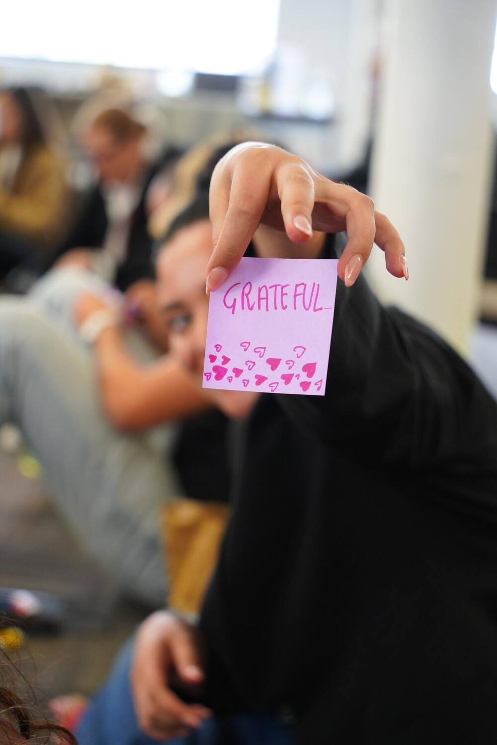 A participant holding up a card with one word about the program