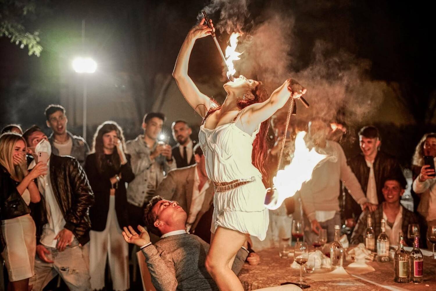 A fire-eater performing between courses at a Veritas dinner in Italy, guests watching