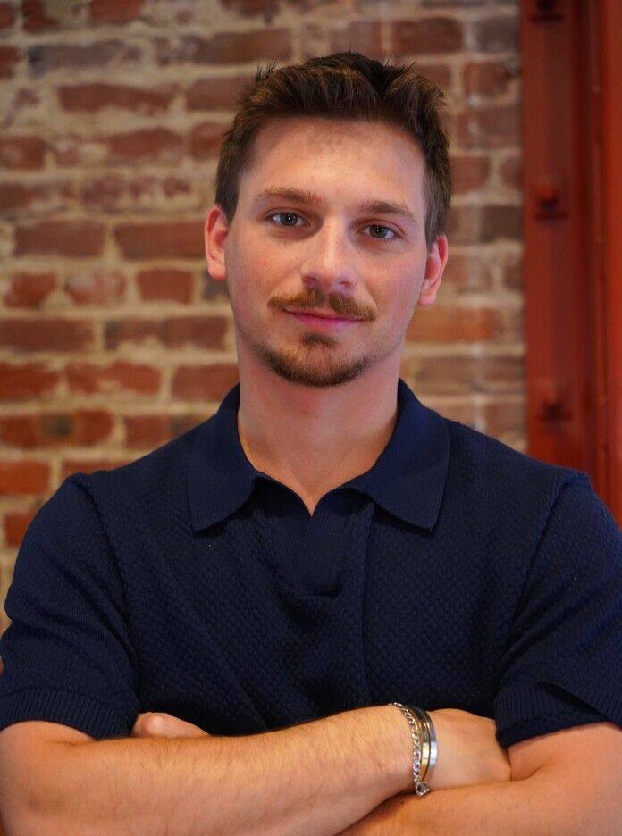 Portrait of Federico Zaninelli, arms crossed, in front of a brick wall