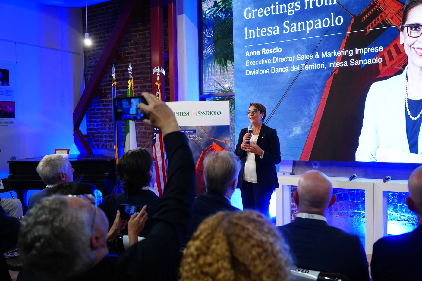Audience filming a speaker at a press event