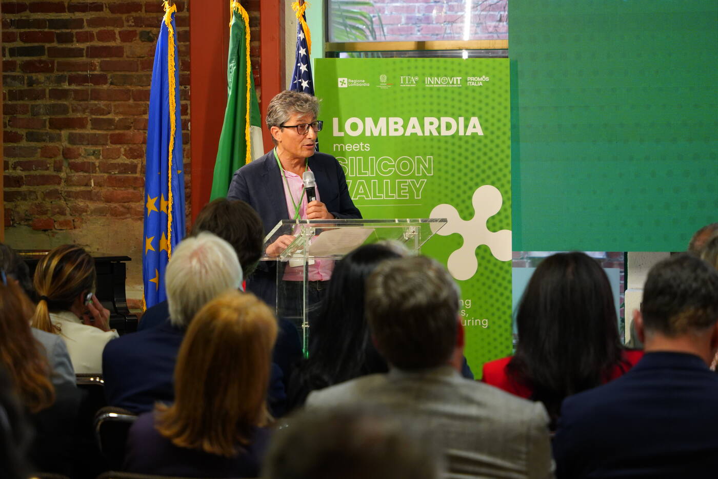 Speaker at a podium with regional flags